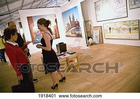 Stock Image - Two Women Watching Exhibition At Art Basel Miami, Miami, Florida, Usa. Fotosearch