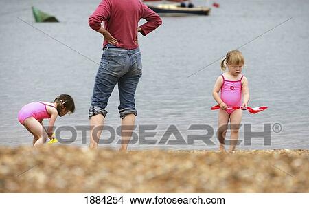 Two Young Girls Playing On The Beach With Their Mother View Large Photo Image Picture - Two Young Girls Playing On The Beach With Their Mother. Fotosearch