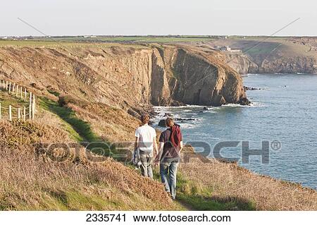 Two Young Men Hiking, St. Non's Bay, Pembrokeshire Coastal Path; Wales, United Kingdom View Large Photo Image Stock Image - Two Young Men Hiking, St. Non's Bay, Pembrokeshire Coastal Path; Wales, United Kingdom. Fotosearch