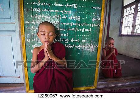 Stock Photo - Two young monks at monastery; Yangoon, Myanmar. Fotosearch