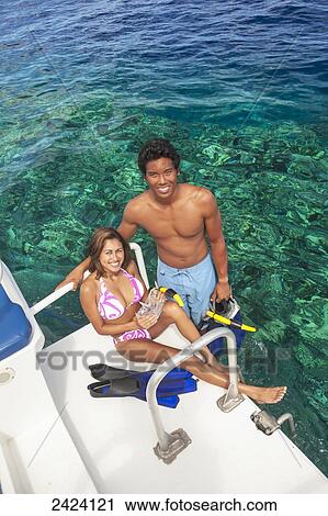 Stock Image - Two young snorkelers on the swimstep of a boat ready for free diving off the island of Maui; Hawaii, United States of America. Fotosearch