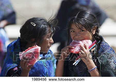 Stock Photograph - Tzotzil Maya Woman And Girl Eating Watermelon, Zinacantan, Chiapas, Mexico. Fotosearch