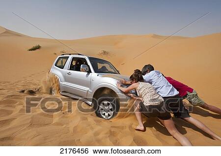 UAE, Abu Dhabi, People trying to push Four wheel drive stuck in soft sand; Liwa View Large Photo Image Stock Photograph - UAE, Abu Dhabi, People trying to push Four wheel drive stuck in soft sand; Liwa. Fotosearch