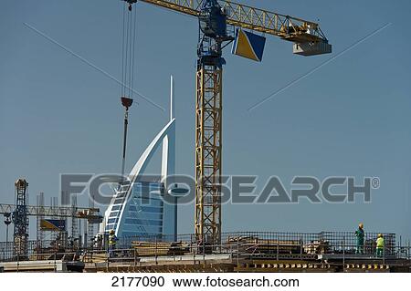 Stock Image - UAE, Construction work in front of Burj Al Arab; Dubai. Fotosearch
