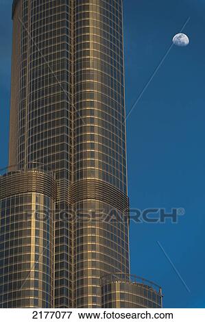 Stock Photo - UAE, Detail of Burj Khalifa with moon rising behind; Dubai. Fotosearch