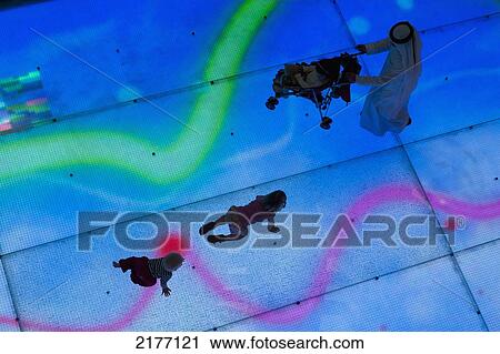 Stock Image - UAE, Dubai Mall shopping centre; Dubai, Looking down on two young children and Arab man with pushchair on illuminated LED floor. Fotosearch