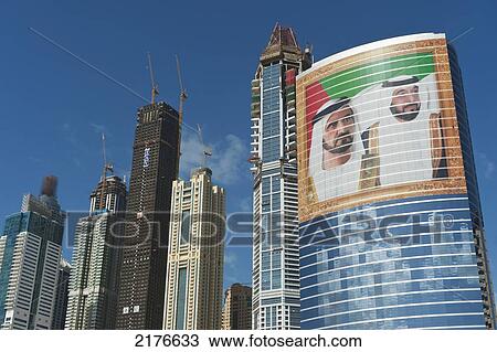 Stock Image - UAE, Large portrait of Sheikh Mohammed Bin Rashid Al Maktoum and Khalifa bin Zayed Al Nahyan on office building; Dubai. Fotosearch