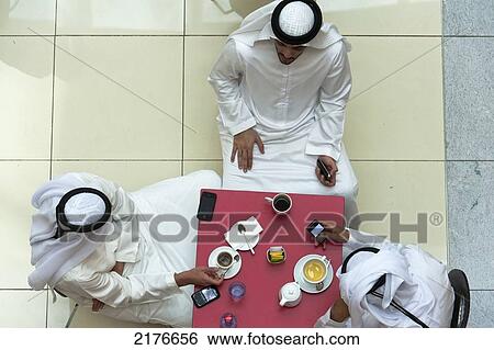 UAE, Looking down on three men having tes-coffee in cafe in Dubai Mall shopping centre; Dubai View Large Photo Image Stock Photograph - UAE, Looking down on three men having tes-coffee in cafe in Dubai Mall shopping centre; Dubai. Fotosearch