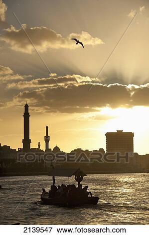 Stock Photo - UAE, People on water taxi at dusk at the Creek; Dubai. Fotosearch
