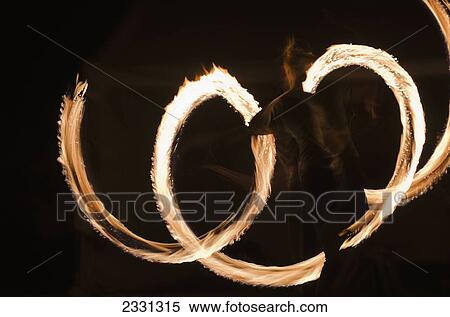 Stock Photography - UK, Berkshire, Man juggling fire at night; Reading. Fotosearch