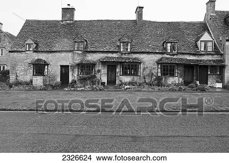 Picture - UK, Cotswolds, Western Cotswolds, Cottages on High Street on rainy day; Broadway. Fotosearch