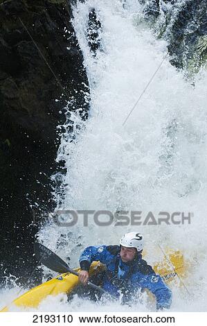 Stock Image - UK, Cumbria, Lake District National Park, Canoeist about to tip over whilst going down Skelwith Force waterfall; Langdale. Fotosearch