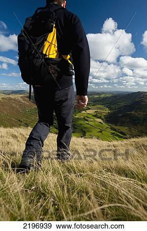 UK, Cumbria, Walker going down hill with view looking along Langdale from near Chapel Stile; Lake District View Large Photo Image Stock Photo - UK, Cumbria, Walker going down hill with view looking along Langdale from near Chapel Stile; Lake District. Fotosearch