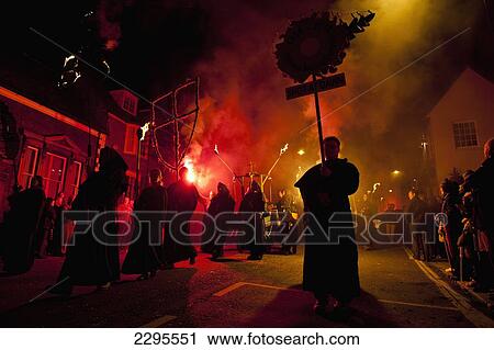 Stock Image - UK, East Sussex, Bonfire night; Lewes, People dressed as monks walking in procession along street with cart. Fotosearch