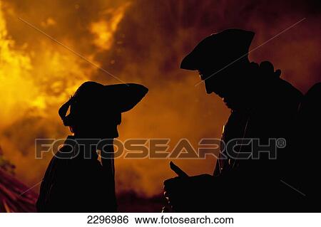 UK, East Sussex, Silhouettes of man and woman dressed as pirates in front of large bonfire; Lewes View Large Photo Image Stock Photograph - UK, East Sussex, Silhouettes of man and woman dressed as pirates in front of large bonfire; Lewes. Fotosearch