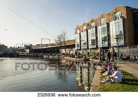Stock Photograph - UK, England, Camden; London, People enjoying a sunny day near Regents Canal. Fotosearch