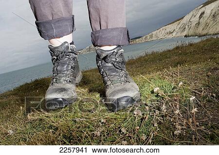 Stock Image - Uk, England, Close-Up Of Boots With Sea In Background; Isle Of Wight. Fotosearch