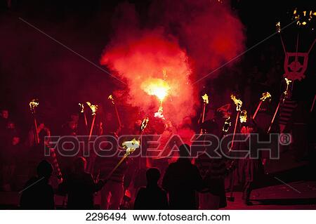 Picture - UK, England, East Sussex, People marching along street with burning torches at Nevill Junior Bonfire night; Lewes. Fotosearch