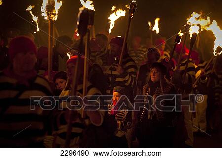 Stock Image - UK, England, East Sussex, People marching along street with burning torches at Nevill Junior Bonfire night; Lewes. Fotosearch