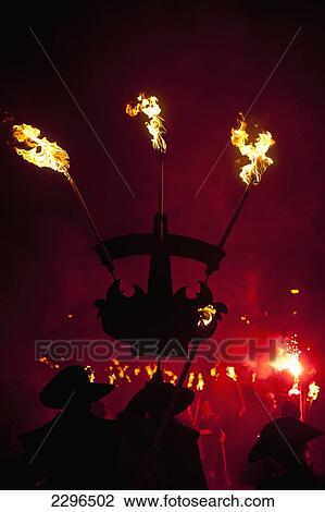 UK, England, East Sussex, Silhouette of man with banner marching along street with burning torches and flare at Nevill Junior Bonfire night; Lewes View Large Photo Image Stock Image - UK, England, East Sussex, Silhouette of man with banner marching along street with burning torches and flare at Nevill Junior Bonfire night; Lewes. Fotosearch