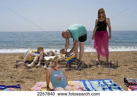 Stock Image - Uk, England, Family On Beach On Freshwater Beach Holiday Park On Jurassic Coast; Dorset. Fotosearch
