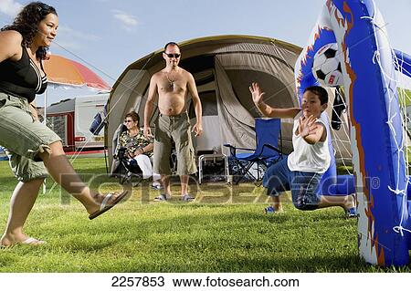 Stock Image - Uk, England, Family Playing Football In Freshwater Beach Holiday Park On Jurassic Coast; Dorset. Fotosearch