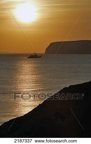 Stock Photo - Uk, England, Fishing Boat And Sunset At Compton Bay; Isle Of Wight. Fotosearch