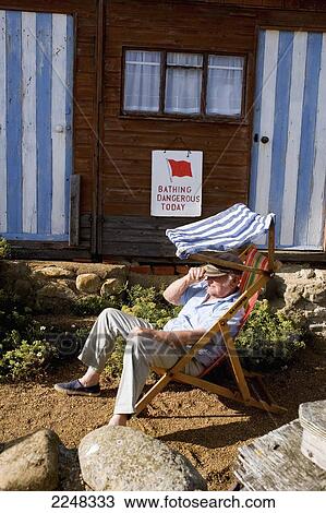 Stock Image - Uk, England, Isle Of Wight, Man Relaxing At Steephill Cove; Ventnor. Fotosearch
