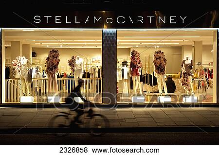 Stock Photo - UK, England, London, Cyclist passing in front of Stella McCartney's shop; Chelsea. Fotosearch