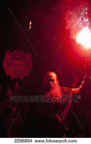 UK, England, Man with red flare in front of banner for Battel Bonfire Boyes walking in procession along main street of Battle for bonfire night; East Sussex View Large Photo Image Picture - UK, England, Man with red flare in front of banner for Battel Bonfire Boyes walking in procession along main street of Battle for bonfire night; East Sussex. Fotosearch