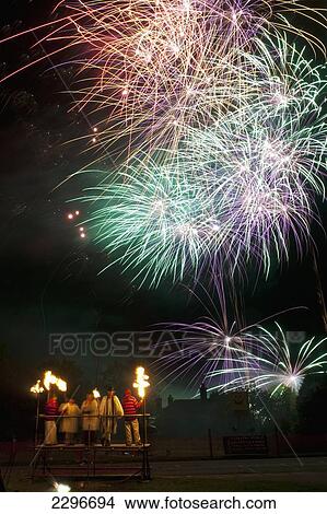 Picture - UK, England, People dressed as clergy on stand with fireworks behind them at Newick bonfire night; East Sussex. Fotosearch