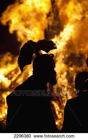 Stock Image - UK, England, Silhouette of Roman Gladiator in front of large bonfire at Battle Bonfire night; East Sussex. Fotosearch