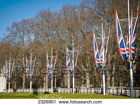 Stock Image - UK, England, Union Jacks in front of Buckingham Palace; London. Fotosearch