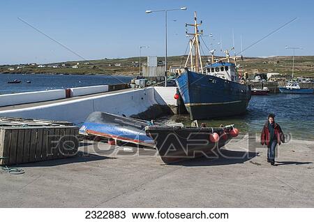 UK, Ireland, County Kerry, Iveragh Peninsula, Portmagee, Woman walking on shore beside fishing boats in harbor View Large Photo Image Stock Image - UK, Ireland, County Kerry, Iveragh Peninsula, Portmagee, Woman walking on shore beside fishing boats in harbor. Fotosearch
