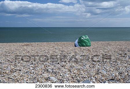Stock Photograph - Uk, Landed Kite On A Pebble Beach; Devon. Fotosearch