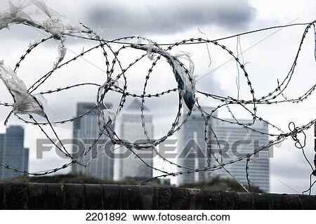 UK, London, Canary Wharf in background; Greenwich Pennisula, plastic bags caught on barbs, Brick wall with barbed wire on top View Large Photo Image Stock Image - UK, London, Canary Wharf in background; Greenwich Pennisula, plastic bags caught on barbs, Brick wall with barbed wire on top. Fotosearch