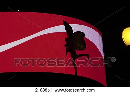 Stock Image - Uk London, Piccadilly Circus, Eros Silhouetted Against Red Electronic Billboard. Fotosearch