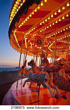 Stock Photography - UK, Merry-go-round on Brighton beach at dusk; East Sussex. Fotosearch