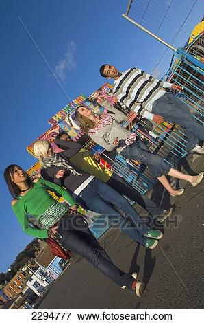 Stock Photo - UK, Mixed group of teenagers at funfair; Hastings. Fotosearch