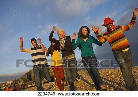 Stock Photograph - UK, Mixed group of teenagers at seaside; Hastings. Fotosearch