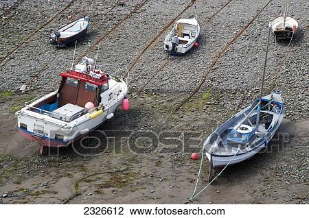 Stock Image - UK, North Devon, Boats at low tide; Clovelly. Fotosearch