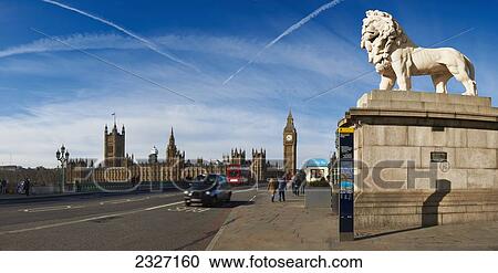 Stock Image - UK, Panoramic view of Houses of Parliament and London Eye from Westminster bridge with London red bus and black taxi; London. Fotosearch