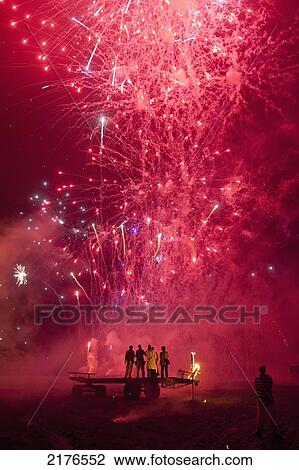 Stock Image - UK, People from Barcombe Bonfire Society 'clergy' on the 'clergy stand' in front of firework display; East Sussex. Fotosearch