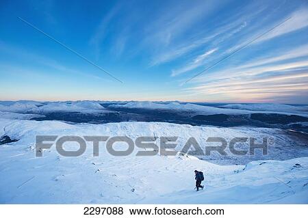 Stock Photo - UK, Scotland, Man descending slopes of Beinn Respiol on Ardnamurchan peninsula; Highlands. Fotosearch