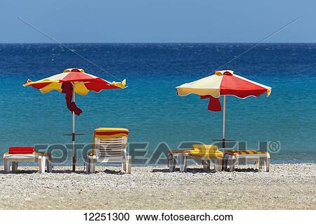 Umbrellas and beach chairs on a beach on the Island of Kos; Kefalos, Greece View Large Photo Image Stock Image - Umbrellas and beach chairs on a beach on the Island of Kos; Kefalos, Greece. Fotosearch