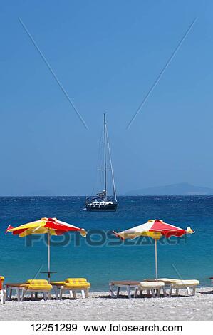 Stock Photo - Umbrellas and beach chairs on a beach on the Island of Kos; Kefalos, Greece. Fotosearch