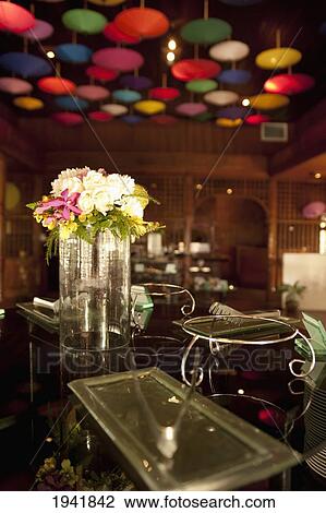 Stock Image - Umbrellas Hanging From The Ceiling And A Flower Vase On The Bar At The Restaurant In Amari Rincome Hotel; Chiang Mai Thailand. Fotosearch