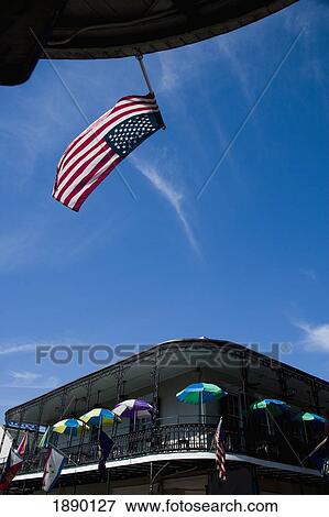 Stock Photo - Umbrellas Line Up On Sunny Balcony With American Flag In Foreground. Fotosearch