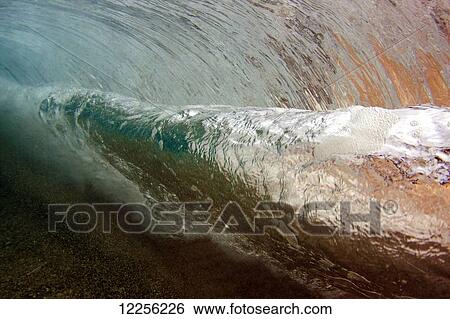 Stock Photograph - Underwater view of a breaking wave; Hawaii, United States of America. Fotosearch