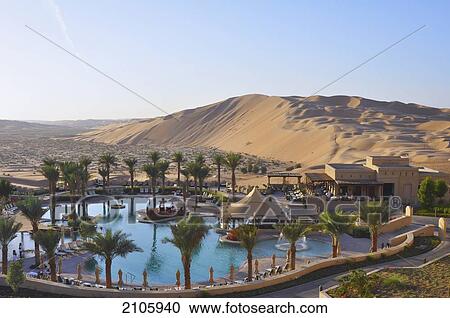 Stock Image - United Arab Emirates, Abu Dahbi, Qasr al Sarab, Qasr al Sarab hotel, Main pool and dunes. Fotosearch